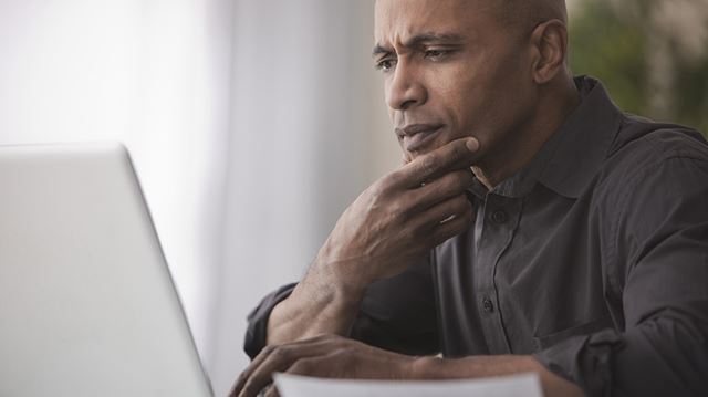 Summer holiday dilemma man looking at laptop